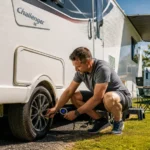Checking tyre pressure on a UK touring caravan before towing