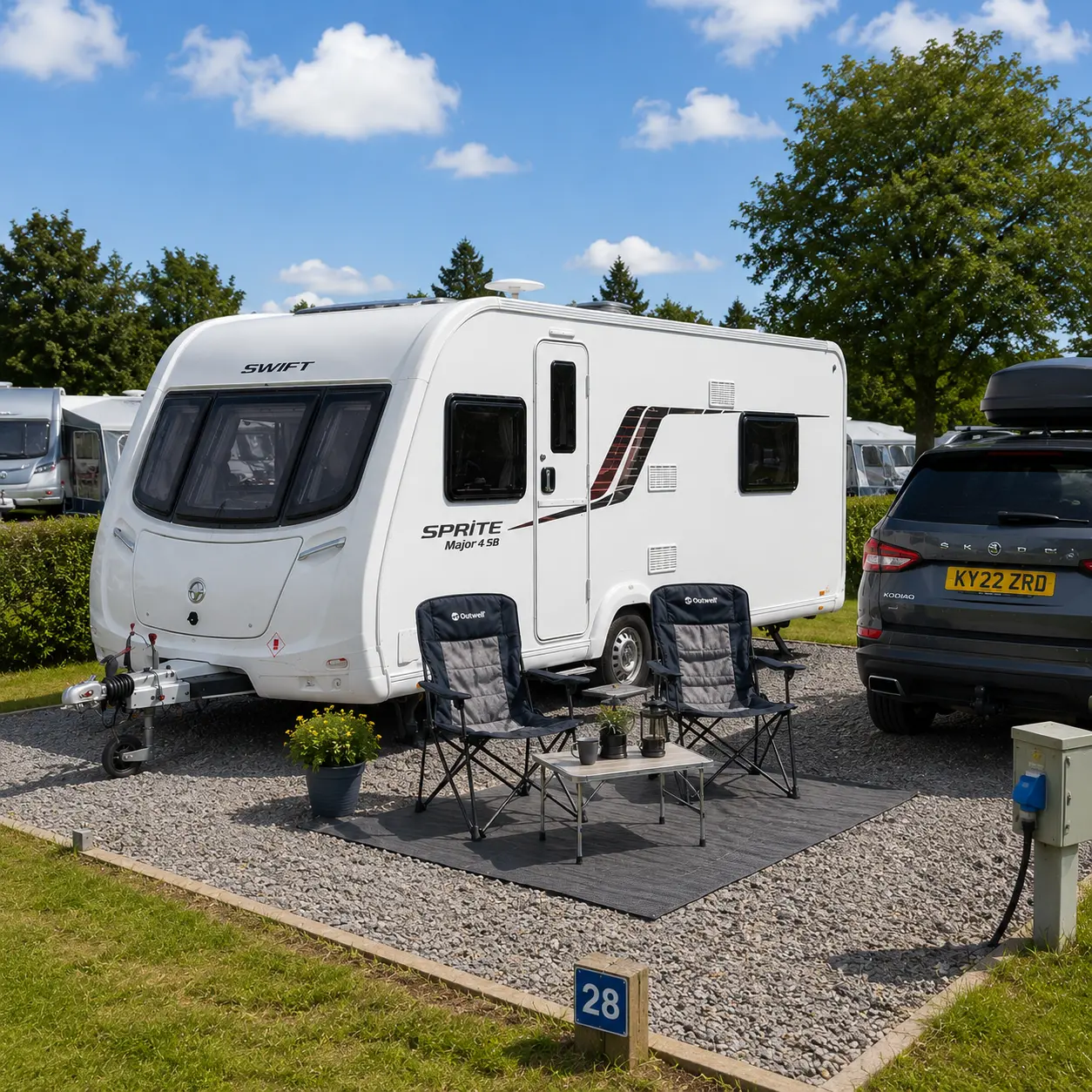 Hardstanding touring pitch setup with UK caravan and outdoor seating area