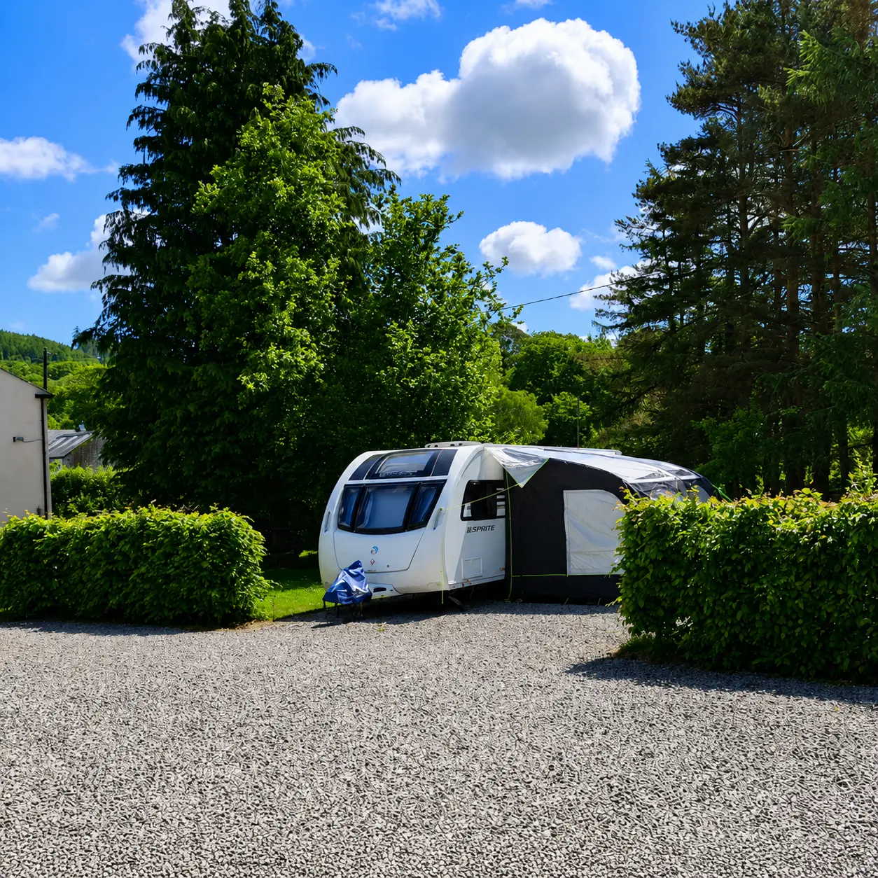 UK touring caravan on a fully serviced pitch with electric, water and waste connections