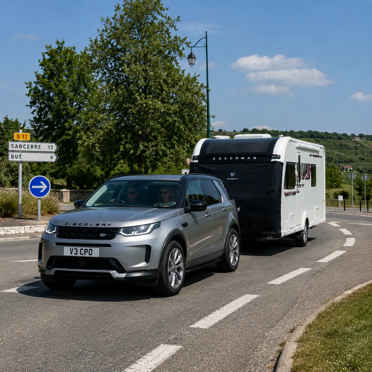 Silver Land Rover Discovery towing a Coachman Sussex Singleton caravan on the right-hand side of a French road