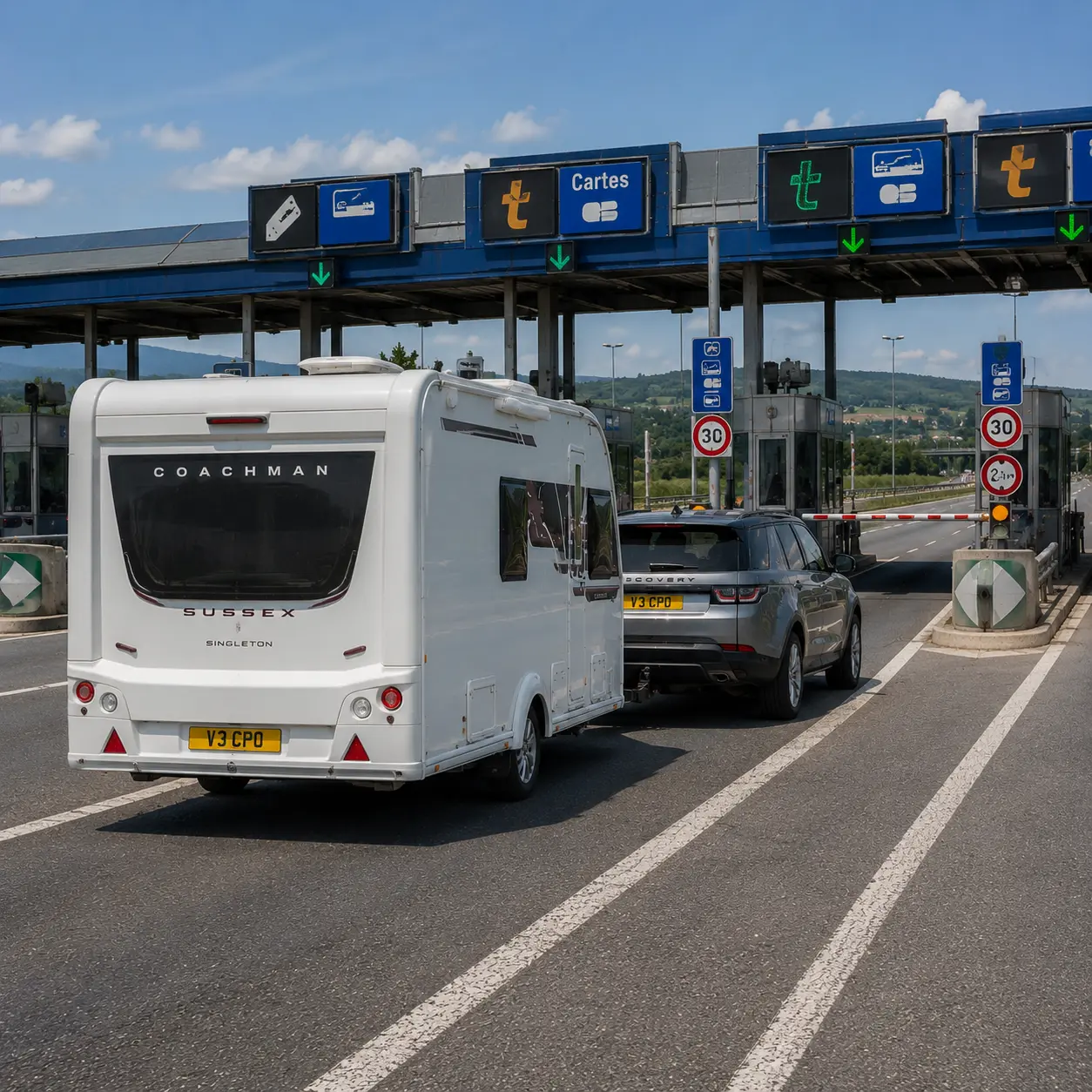 Silver Land Rover Discovery towing a Coachman caravan towards a French autoroute toll station