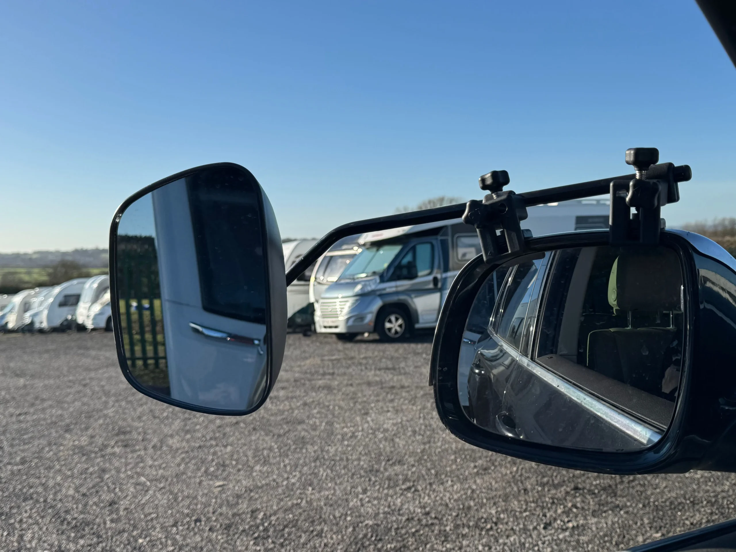 Driver adjusting caravan towing mirrors before departure