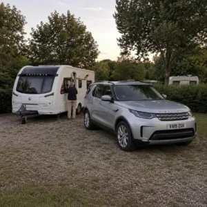 Silver Land Rover Discovery and Coachman Sussex Singleton caravan parked on an overnight touring pitch in Europe